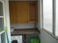 galería donde esta lavadora y nevera toda forrada en muebles de roble
